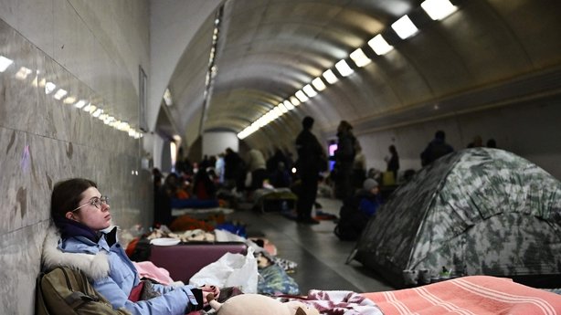 A woman sits in a makeshift bomb shelter in a Kyiv metro station